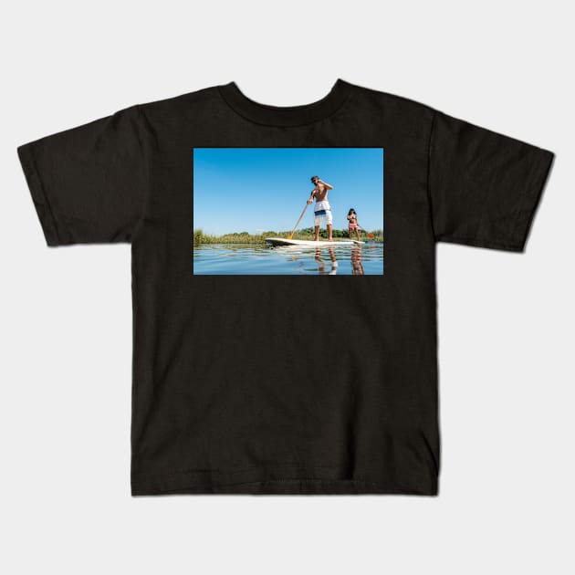 Man and woman stand up paddleboarding Kids T-Shirt by homydesign
